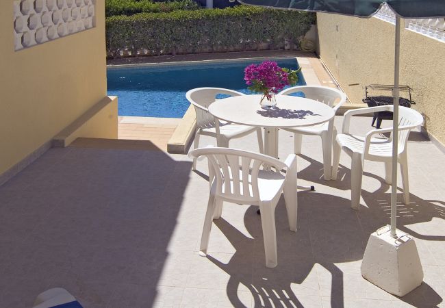 Small, side terrace with table above the pool Small, side terrace of Villa Beatriz above the pool with table, parasol and chairs