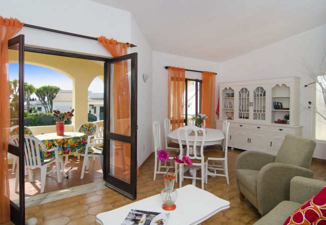 Living room with dining table and access to the covered terrace Living room of Villa Beatriz with dining table and seating area and French doors to the covered terrace