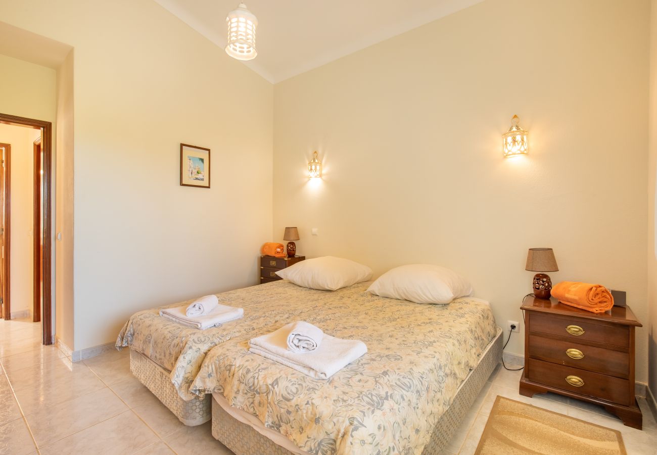 Cozy Bedroom with Twin Beds and Warm Lighting A bright bedroom with two single beds, two nightstands, and warm wall lamps.