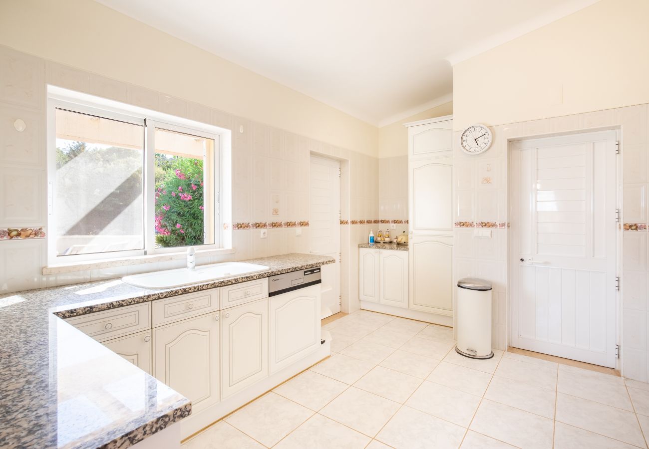 Bright Kitchen with Granite Countertops A modern kitchen with white cabinets, granite countertops, and a large window.
