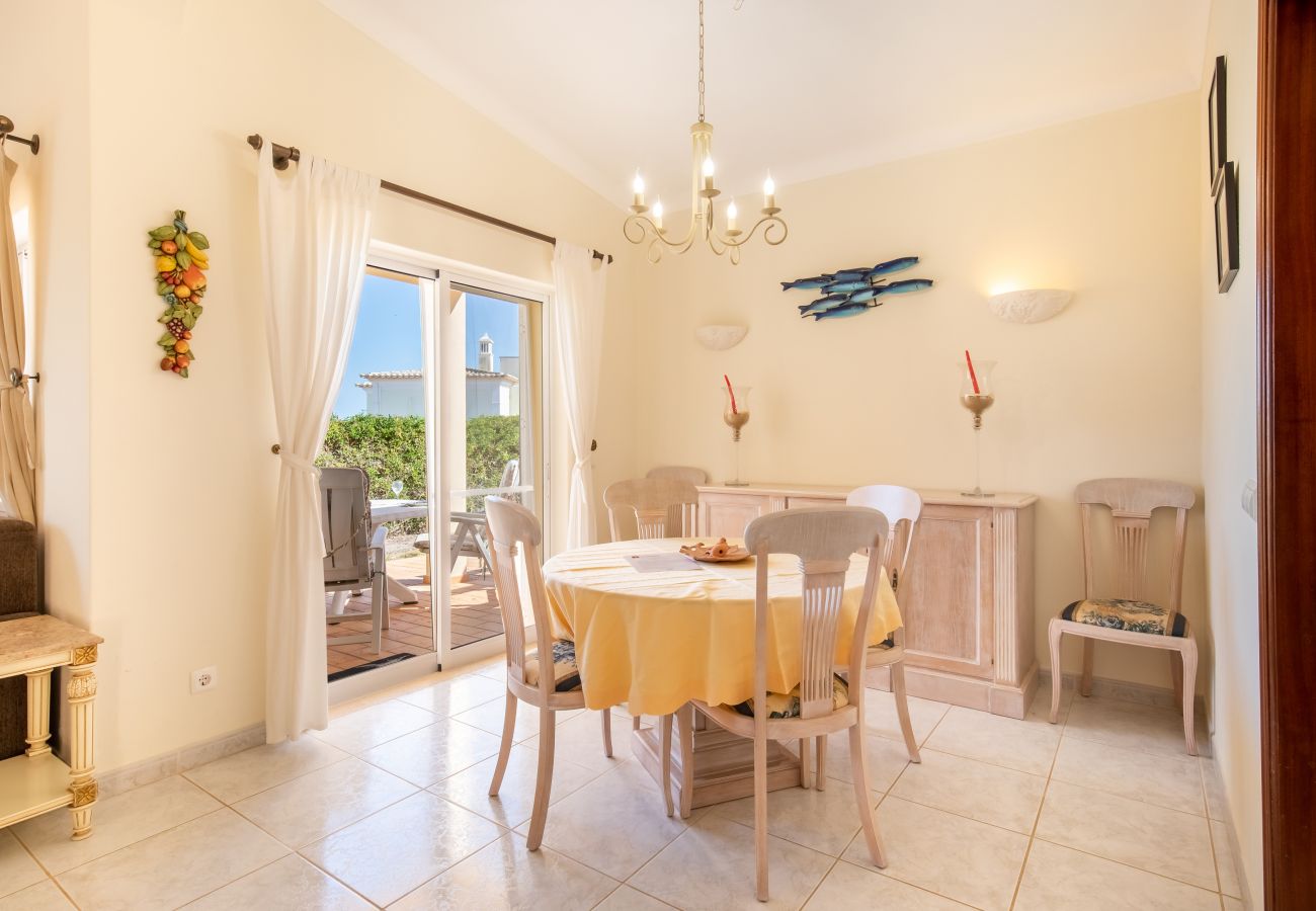 Bright dining area with a round table and a patio door. Interior of a bright dining area with a round table and chairs and a large glass door.