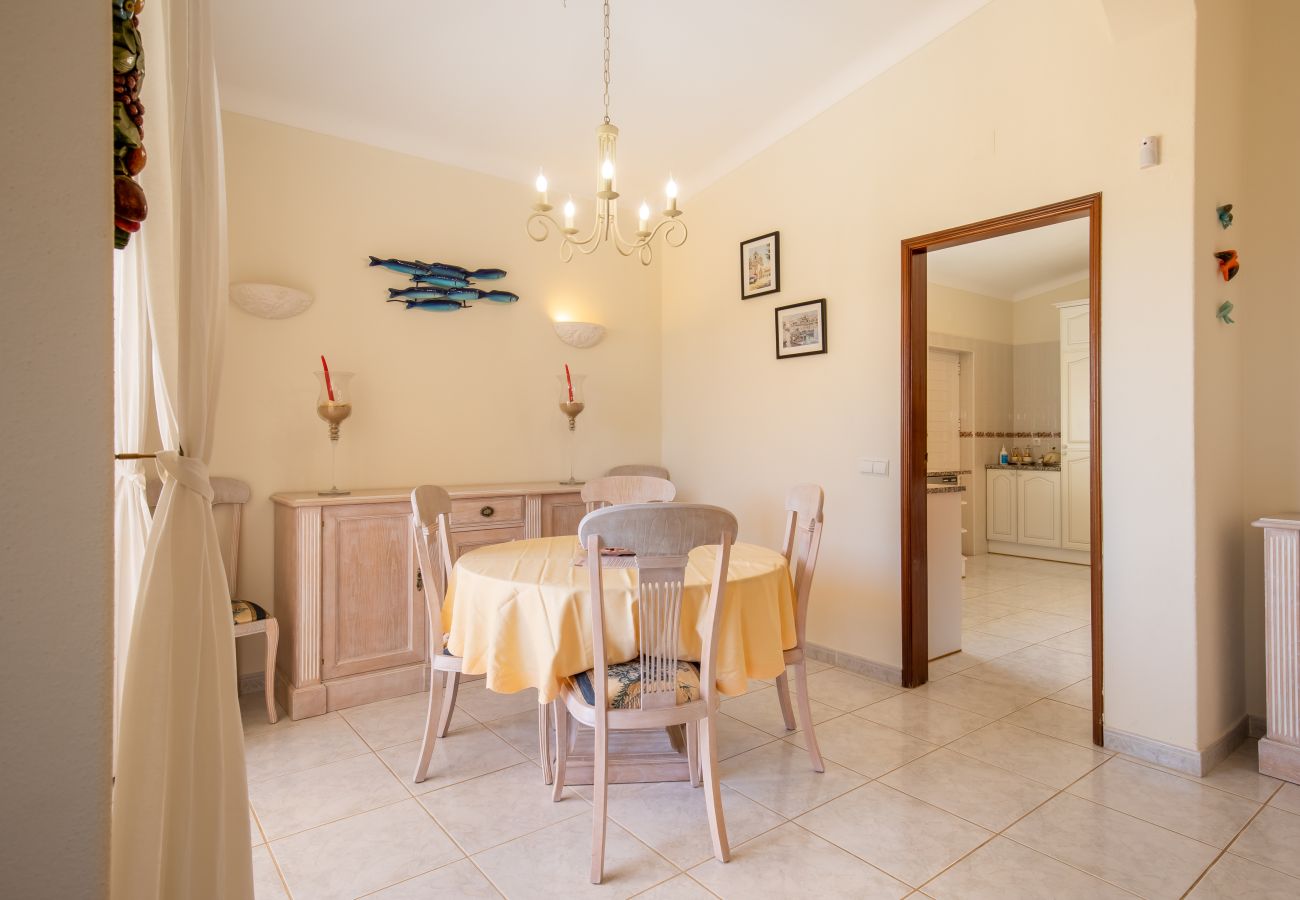 Bright dining area with a round table and a patio door. Interior of a bright dining area with a round table and chairs and a large glass door.