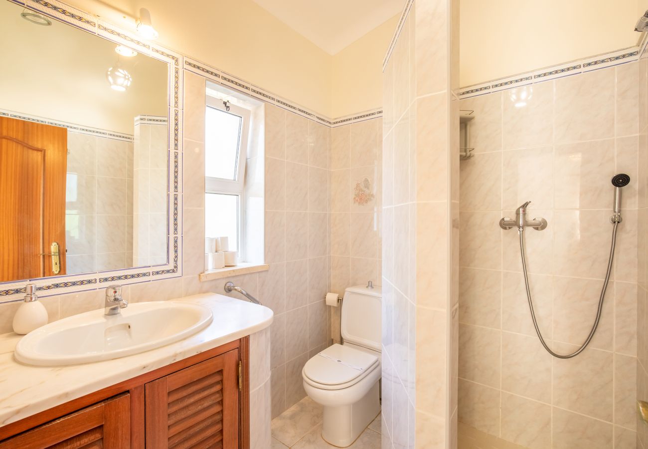 Classic Bathroom with Double Vanity and Bidet A classic bathroom with light tiles, wood cabinets, a double vanity, and bidet.