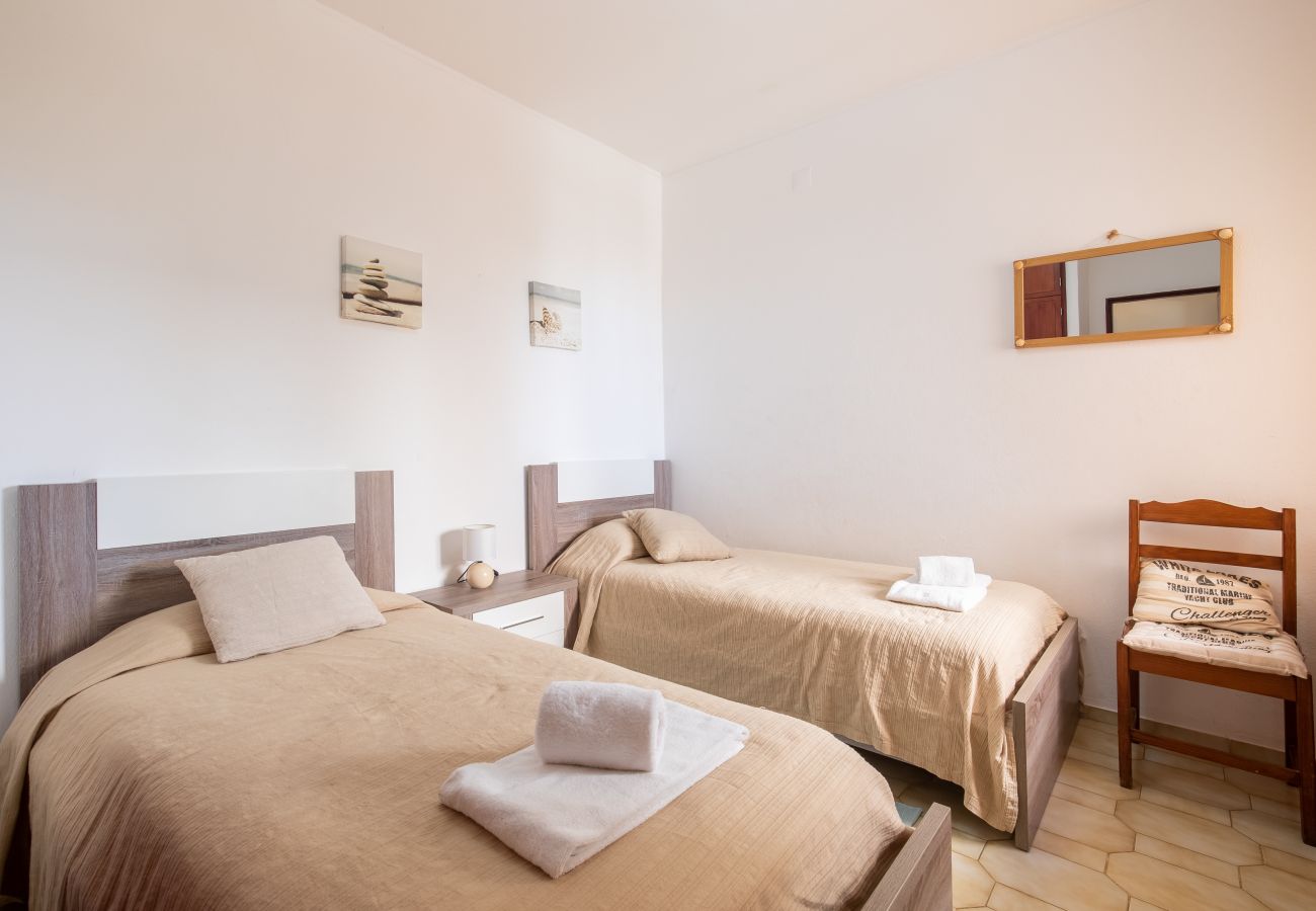 Tranquil Twin Bedroom with Modern Wood Beds and Light Decor Twin bedroom featuring two single beds, nightstand, beige bedding, light wall art, wooden mirror, and tiled floor.