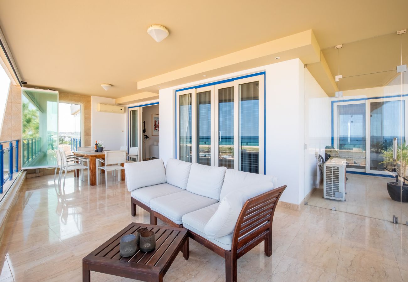 Spacious Ocean View Balcony with Seating and Dining Wide shot of a balcony with outdoor sofa, coffee table, and ocean view in the background.