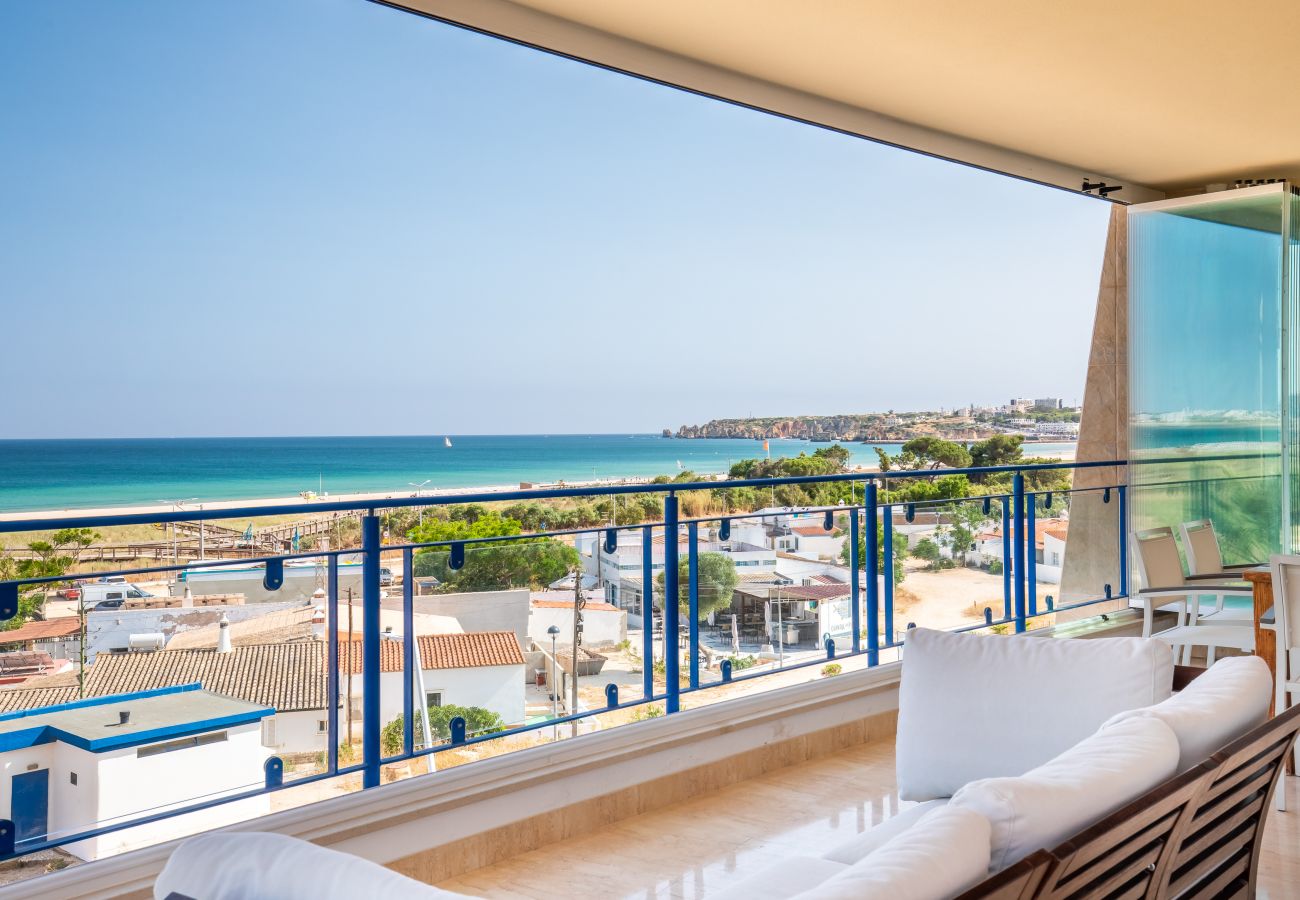 Expansive Ocean View Balcony with Outdoor Seating Wide outdoor balcony with comfortable seating and panoramic views of the ocean and coastline.
