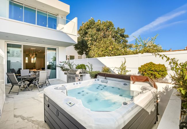 Spacious outdoor leisure area with jacuzzi, garden furniture, and barbecue.