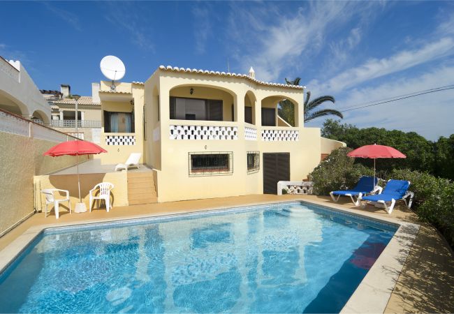 Piscina Villa Beatriz com espreguiçadeiras azuis no terraço e guarda-sol
