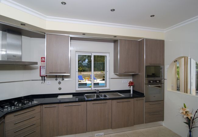 Cozinha moderna com vista para a piscina cozinha moderna com fogão a gás, forno e micro-ondas na Vivenda Zabra com vista para a piscina