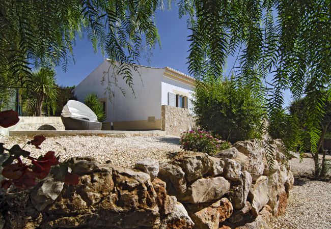 Vivenda Zabra Jardim com espreguiçadeira ao lado da casa Vivenda Zabra Jardim com espreguiçadeira ao lado da casa