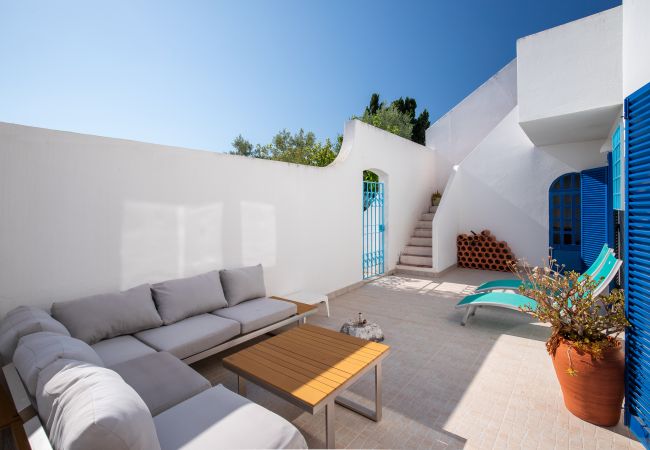 Pátio com Área de Lounge, Escadas e Portão Azul Pátio exterior com conjunto de lounge, espreguiçadeiras, escadas e portão azul.