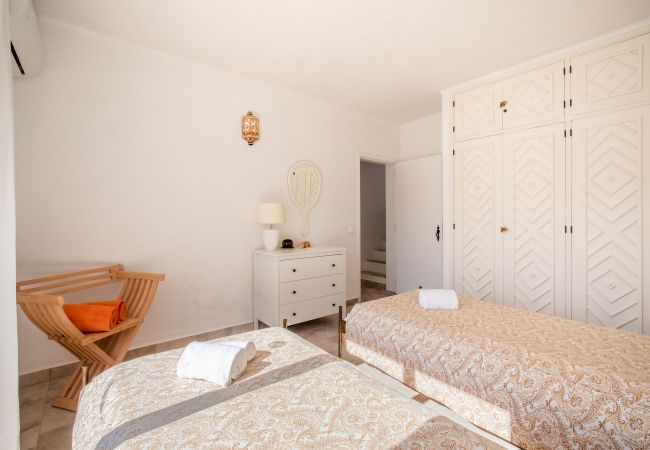 Quarto espaçoso com duas camas de solteiro e guarda-roupa Quarto luminoso com duas camas de solteiro, um grande guarda-roupa branco e uma cômoda.