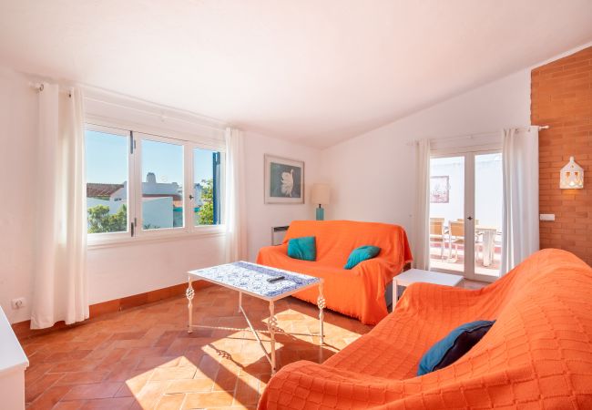 Sala de Estar com Acesso ao Terraço Sala de estar com dois sofás laranja e chão de azulejos.