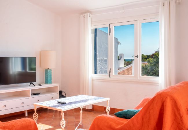 Sala de Estar com Vista para o Mar Sala de estar com sofás e uma janela com vista para os arredores e para o mar.