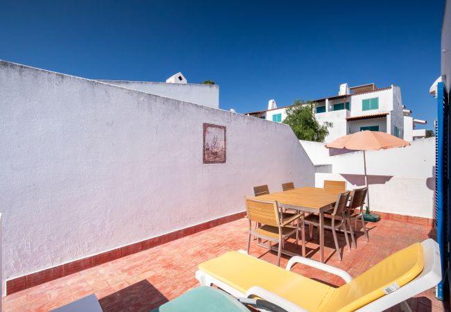 Terraço na Cobertura com Área de Jantar e Espreguiçadeiras Terraço na cobertura com mesa de jantar, cadeiras, guarda-sol e espreguiçadeiras.