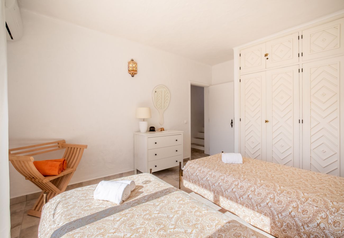 Quarto espaçoso com duas camas de solteiro e guarda-roupa Quarto luminoso com duas camas de solteiro, um grande guarda-roupa branco e uma cômoda.