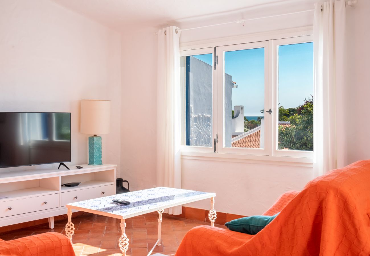 Sala de Estar com Vista para o Mar Sala de estar com sofás e uma janela com vista para os arredores e para o mar.
