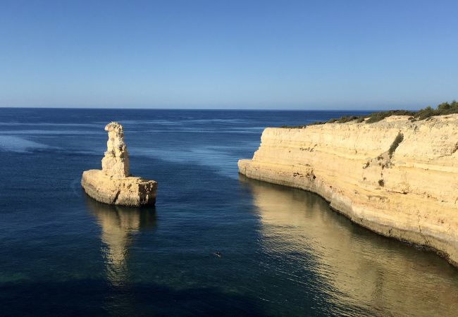 Mar calmo e deserto nas primeiras horas da manhã Mar calmo e deserto com costa rochosa nas horas da manhã no Algarve