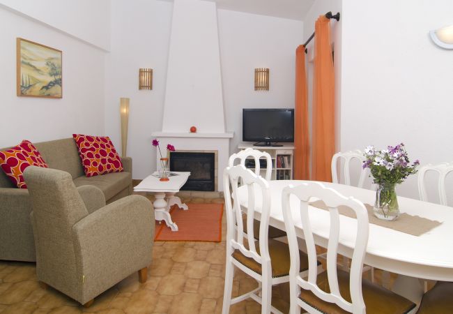 Esstisch im Wohnzimmer sowie Sofa und TV neben dem Kamin Esstisch für sechs Personen im Wohnzimmer der Villa Beatriz und Sofa und Fernseher direkt neben dem Kamin.
