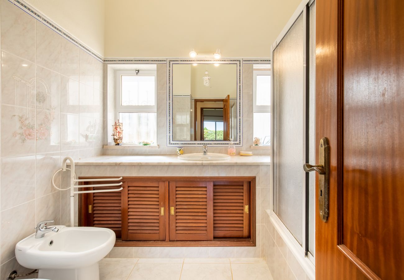 Klassisches Badezimmer mit Doppelwaschbecken und Bidet Ein klassisches Badezimmer mit hellen Fliesen, einem Holzschrank, Doppelwaschbecken und Bidet.