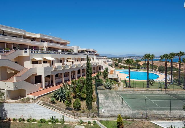 Tennisspielen unter Palmen mit Meerblick Tennisplatz und Gemeinschaftspool mit Meerblick im Resort Iberlagos