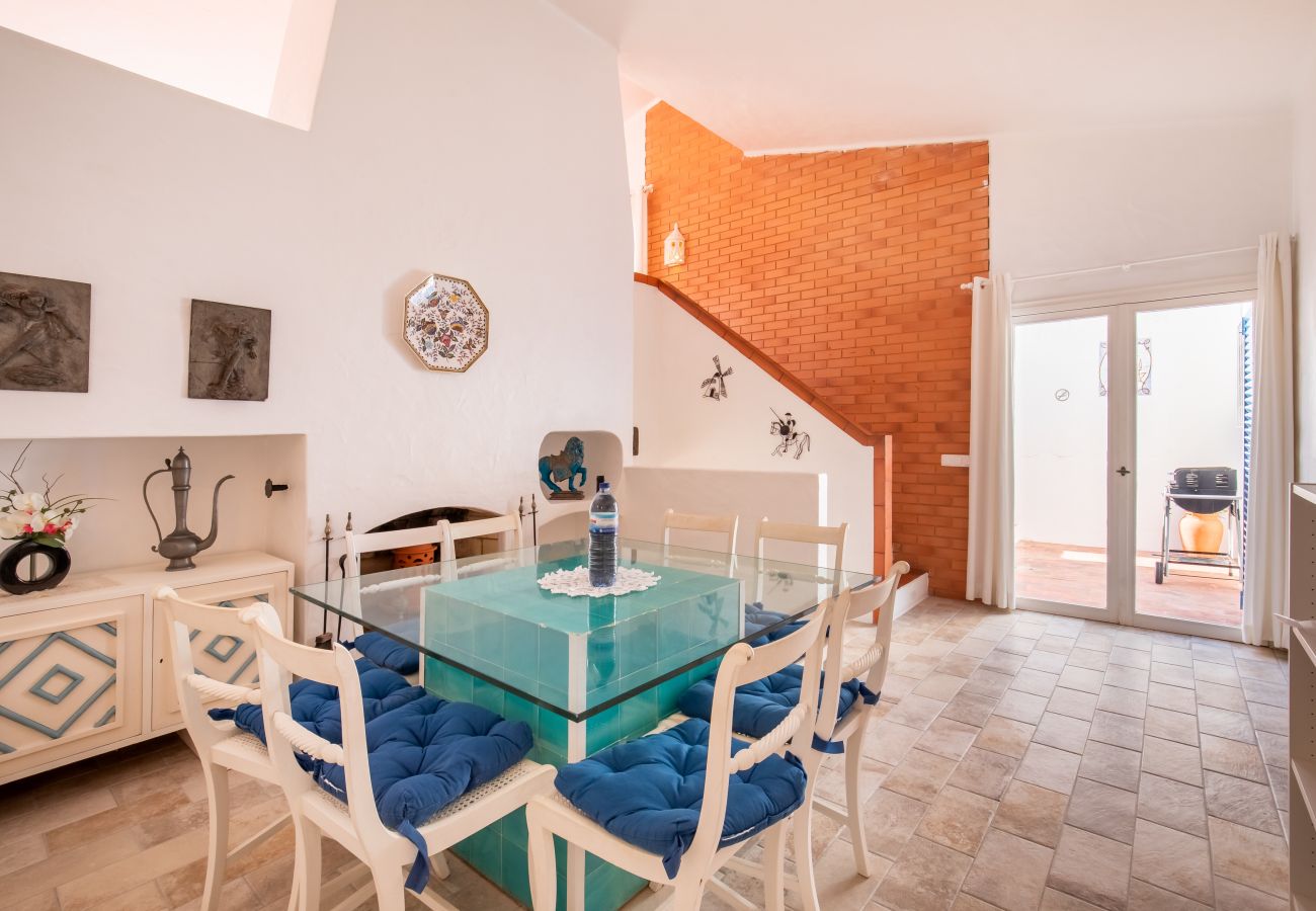 Essbereich mit Treppe und Patio-Zugang Essbereich mit Glastisch, Stühlen und offenem Zugang zu einem Patio mit Grill.