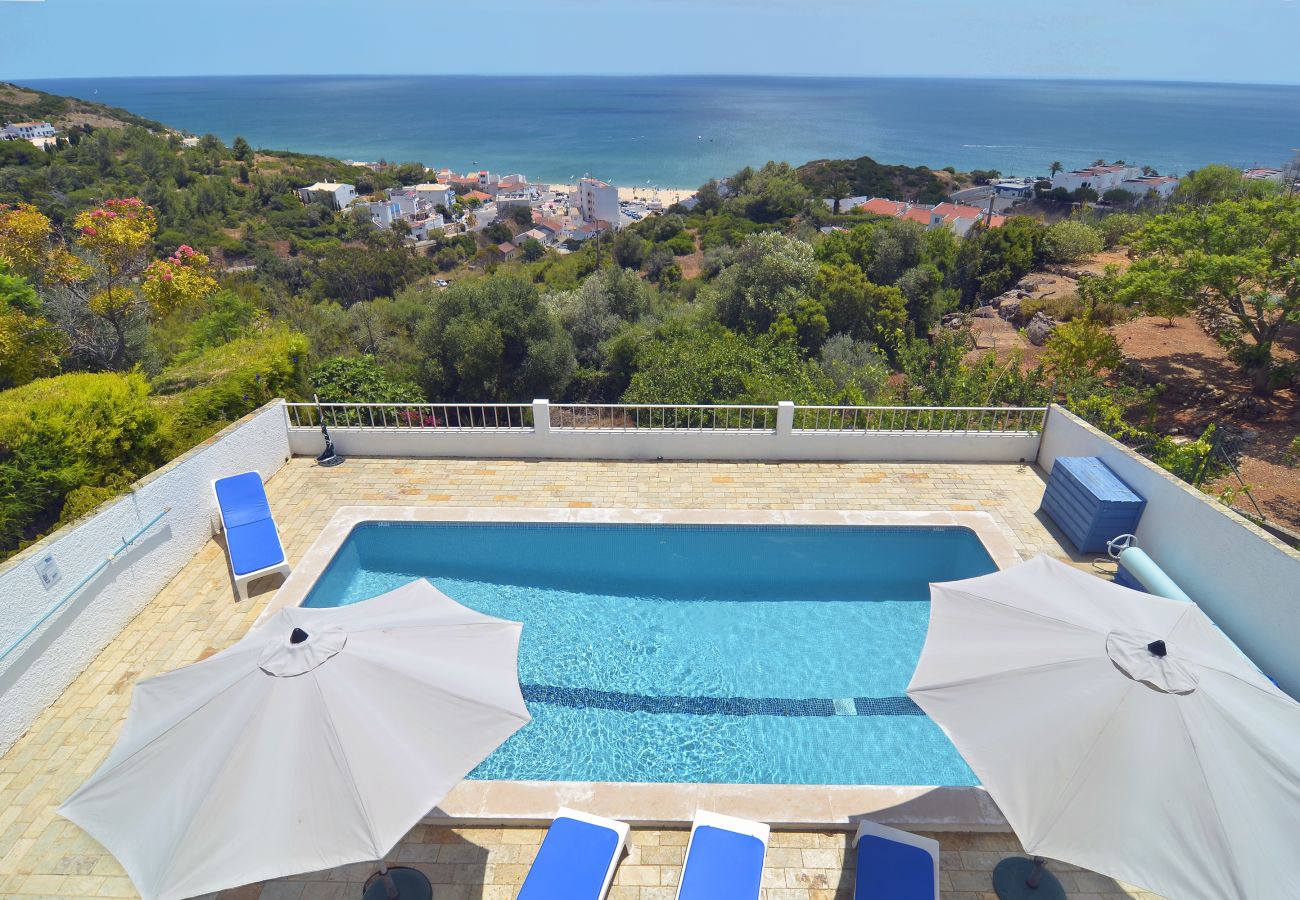 Poolbereich von Villa Katiya mit Sonnenliegen und Strandblick Blick auf den von Sonnenliegen umgebenen Pool von Villa Katiya und den Ortskern und Strand von Salema