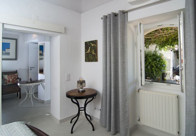 Kleiderschrank, rustikale Bank und Fenster in kleinem Schlafzimmer  Kleiderschrank und rustikale Holzbank mit Beistelltisch in kleinem Schlafzimmer in Casa Palmeira