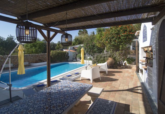 Überdachte Terrasse mit Grill Überdachte Terrasse mit Bänken und Grill im Garten von Casa Palmeira mit Blick auf den hauseigenen Pool