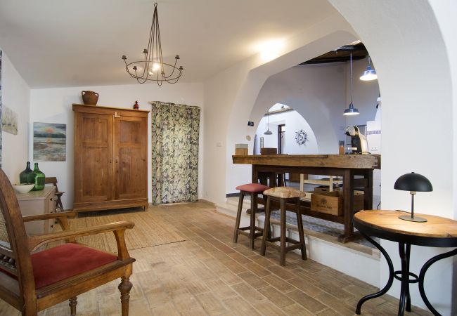 Holztheke mit Barhockern zwischen Küche und Wohnzimmer  Lange Holztheke mit zwei Barhockern im Wohnzimmer neben den Stufen zur Küche in Casa Palmeira