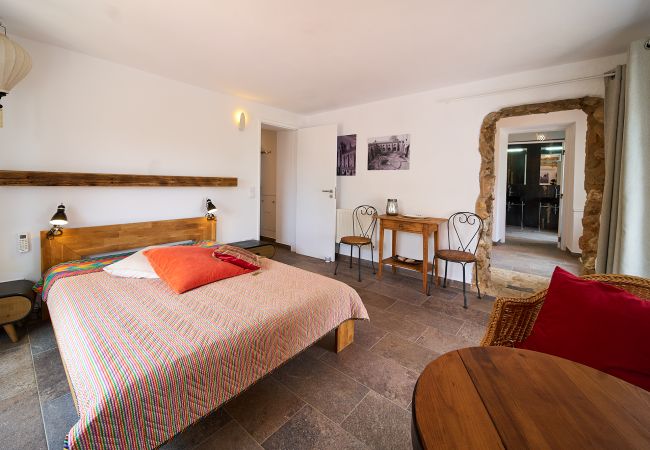 Schlafzimmer mit Doppelbett Rustikal eingerichtetes Zimmer mit einem großen Doppelbett und einem ungewöhnlichen Steinrahmen gegenüber dem Badezimmer