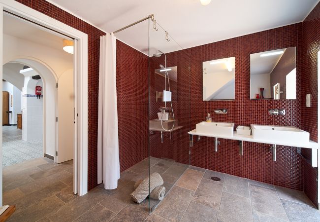 Rot gefliestes Bad mit 2 Waschbecken, Dusche und beheiztem WC Rot gefliestes Badezimmer in Casa Palmeira mit zwei Waschbecken und großer ebenerdiger Dusche