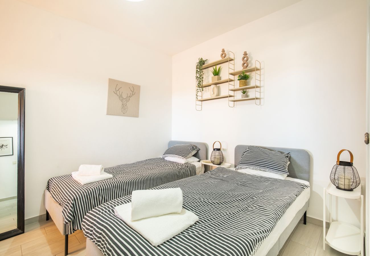 Helles Zweibettzimmer mit Modernen Regalen und Streifen Helles Zweibettzimmer mit grau-weiß gestreiften Betten, einem Ganzkörperspiegel und dekorativen Wandregalen.