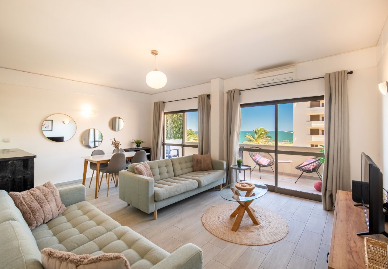 Lichtdurchflutetes Wohnzimmer mit Meerblick und Stil Helles Wohnzimmer mit zwei Sofas, Esstisch, runden Spiegeln und einem Balkon mit weitem Meerblick.