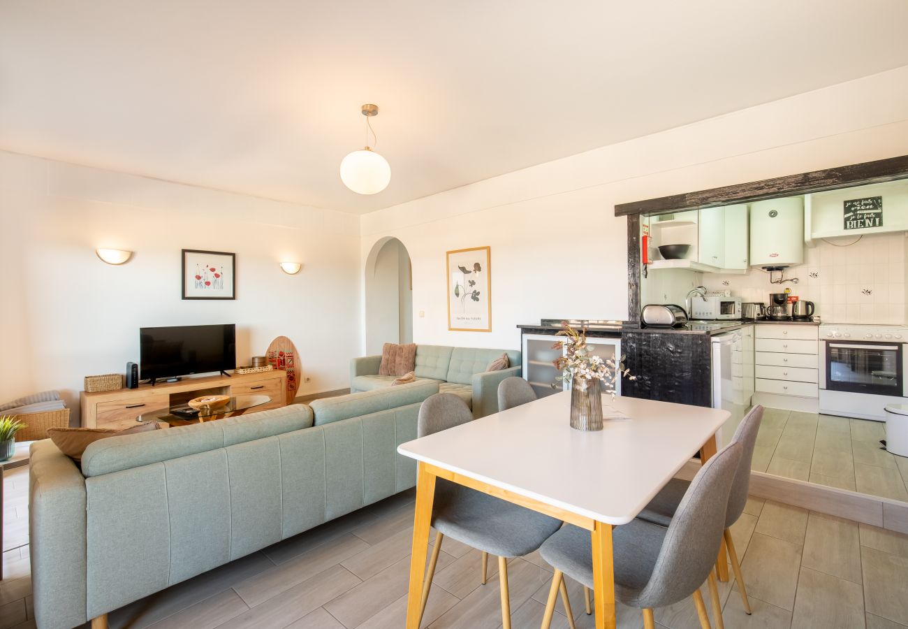 Stilvoller Schminktisch und Dekoratives Regal Weißer Schminktisch mit quadratischen Spiegeln, Pflanzen und einem weißen Regal mit Rattankörben und Dekokopf.