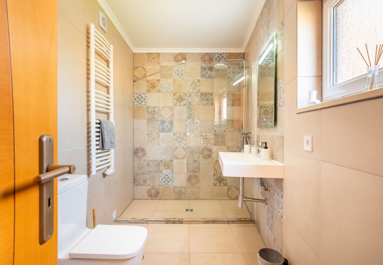 Modernes Badezimmer mit begehbarer Dusche auberes Badezimmer mit begehbarer Dusche, wandmontiertem Waschbecken, Toilette und beheiztem Handtuchhalter.