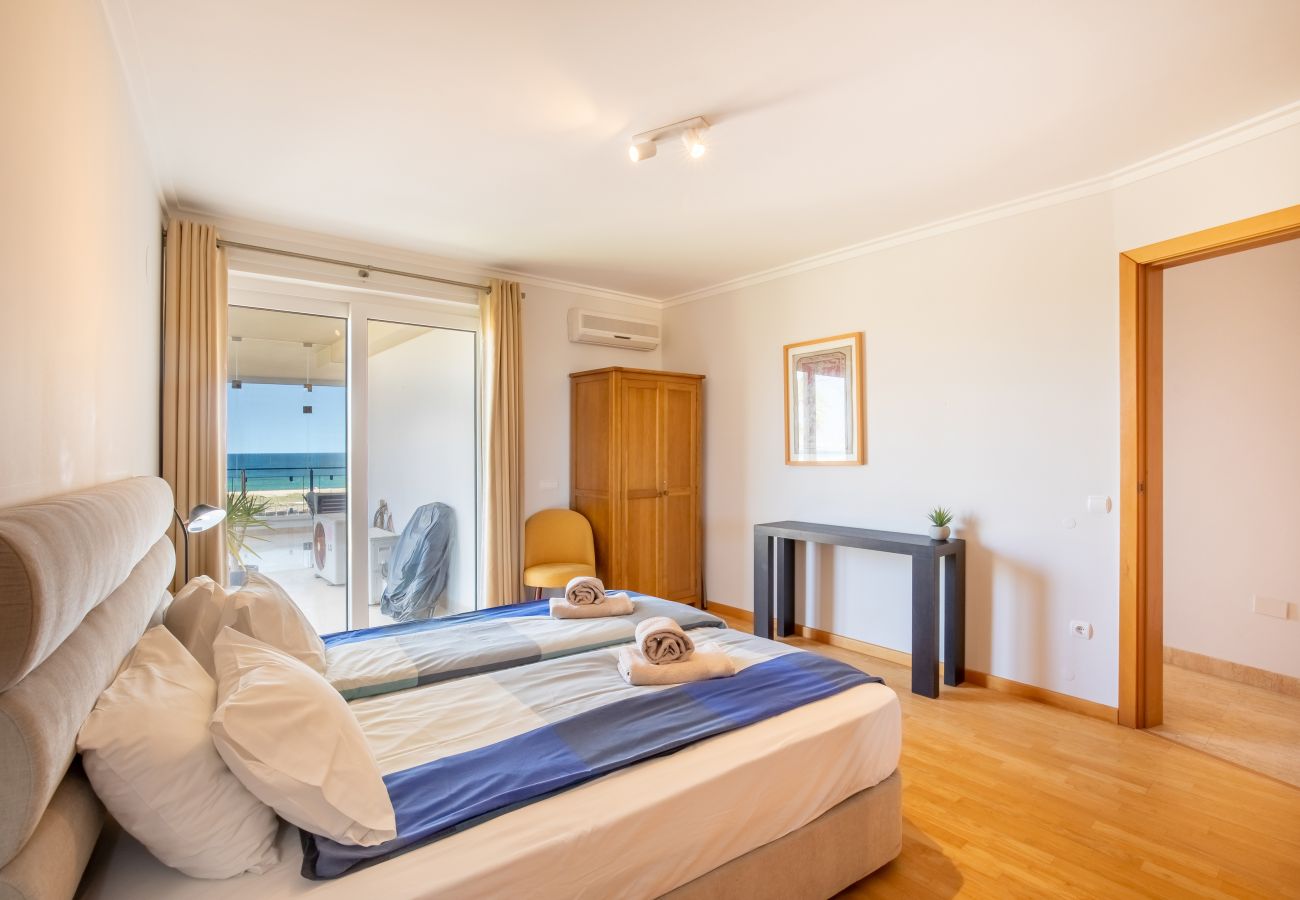 Komfortables Schlafzimmer mit Balkonzugang und seitlichem Meerblick Schlafzimmer mit Doppelbett, Holzschrank und offener Balkontür mit seitlichem Meerblick.