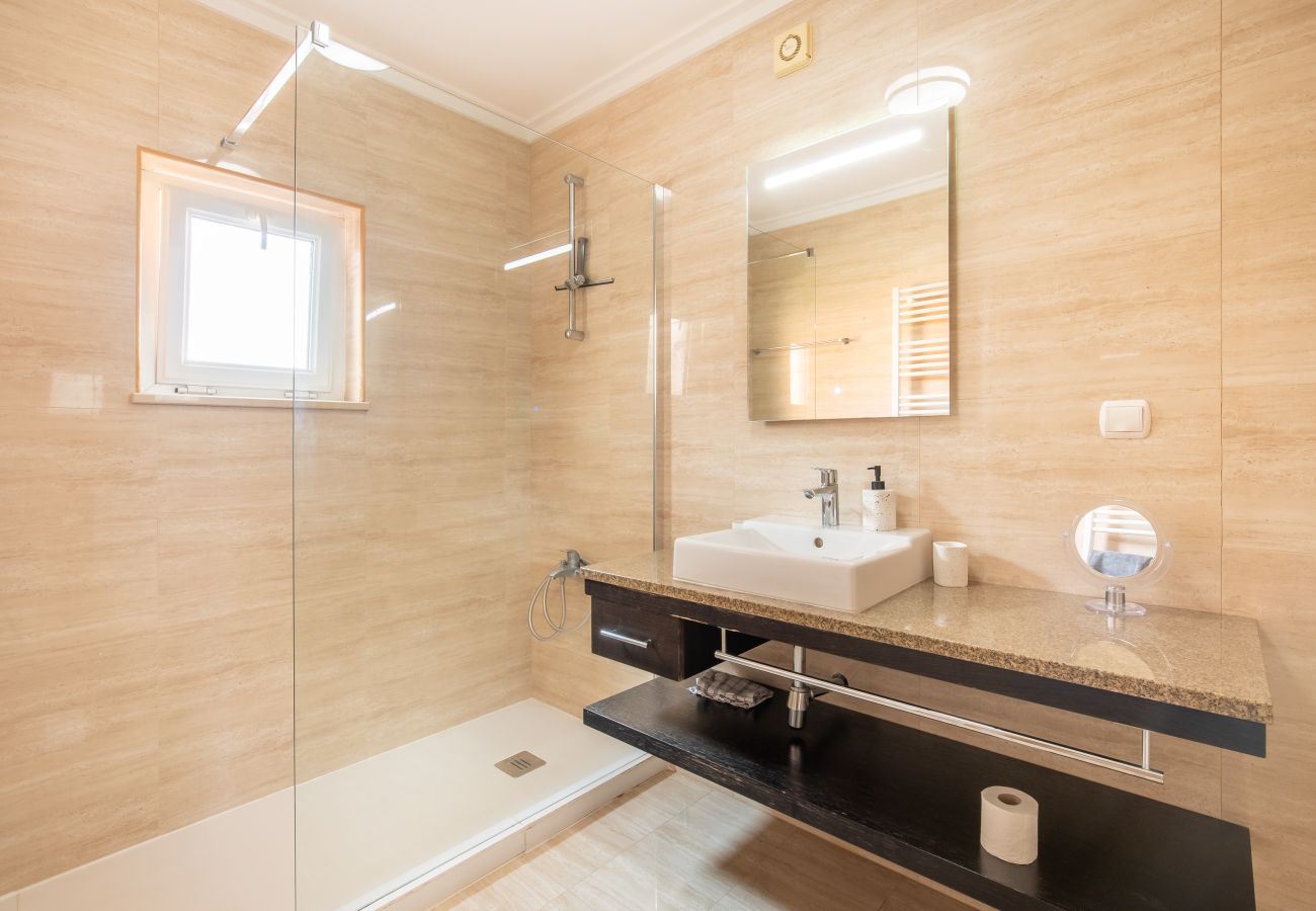 Modernes Badezimmer mit begehbarer Dusche Sauberes Badezimmer mit begehbarer Dusche, quadratischem Waschbecken auf modernem Waschtisch und Spiegel.